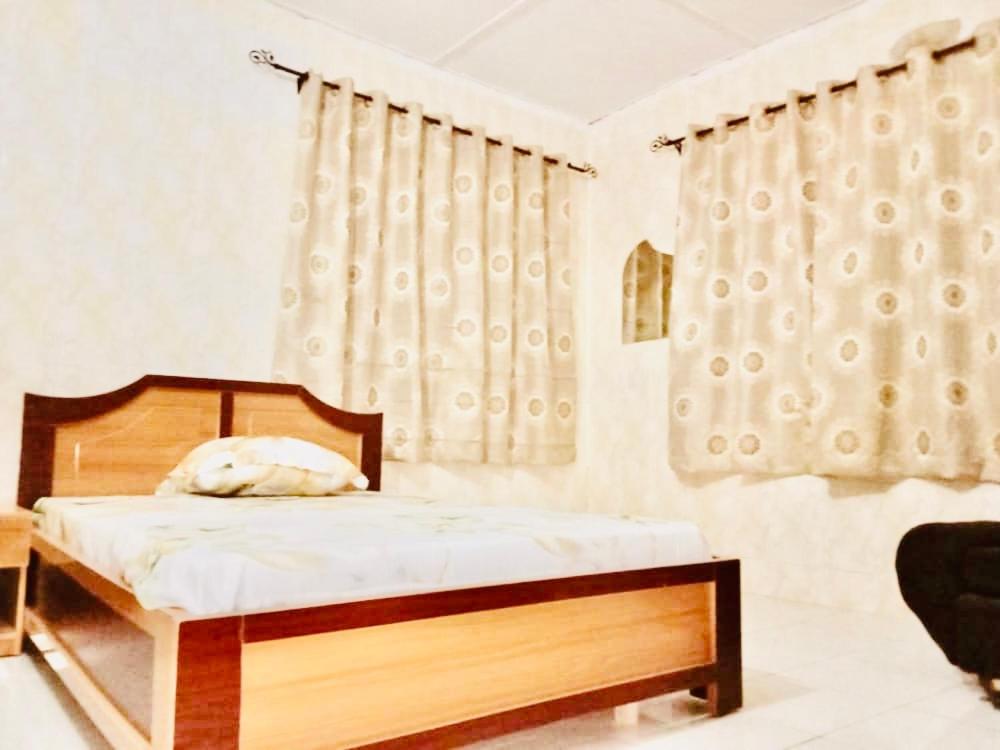 a bedroom with a bed with a wooden frame and curtains at 8 bedroom holiday home with great ambiance in Ofatedo