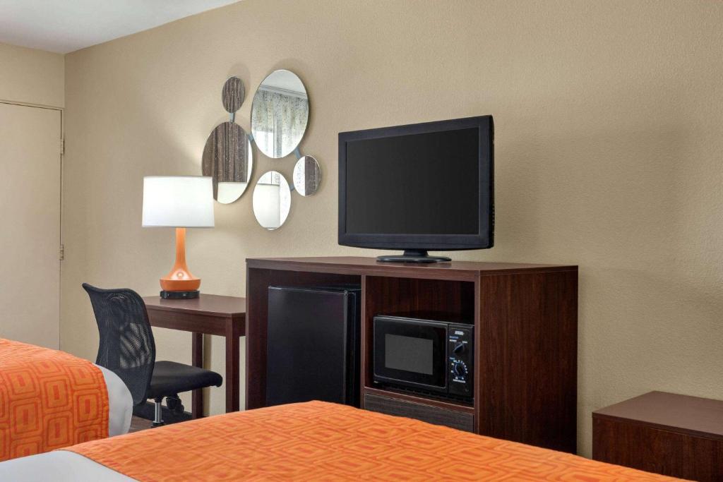 a hotel room with a flat screen tv on a cabinet at Howard Johnson by Wyndham Pigeon Forge in Pigeon Forge