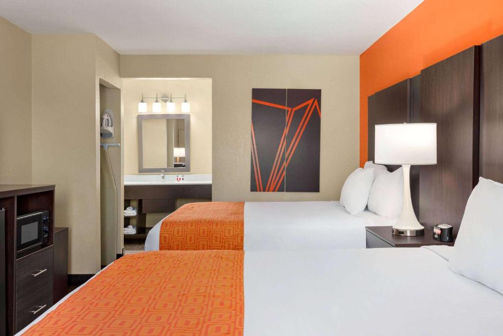 a hotel room with two beds and a bathroom at Howard Johnson by Wyndham Pigeon Forge in Pigeon Forge