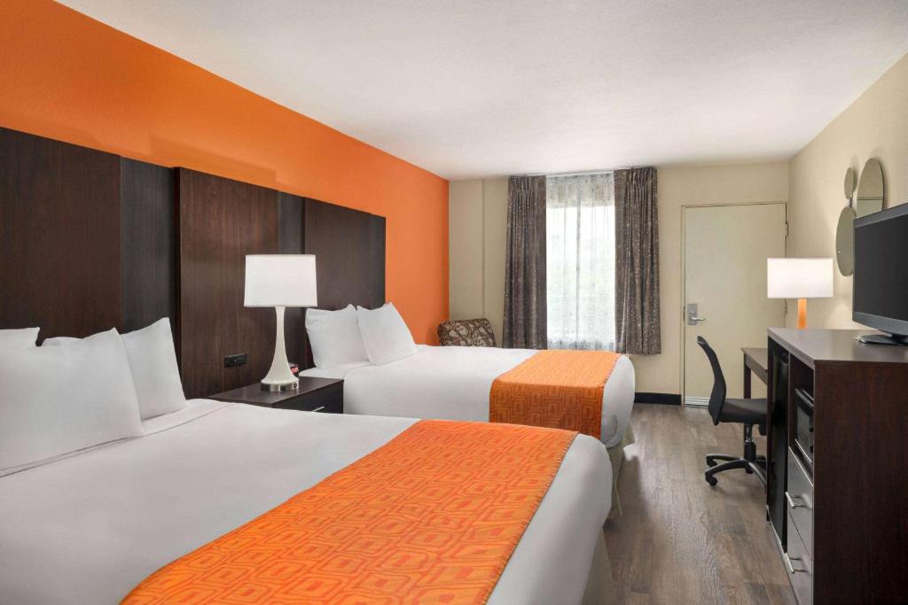 a hotel room with two beds and a flat screen tv at Howard Johnson by Wyndham Pigeon Forge in Pigeon Forge