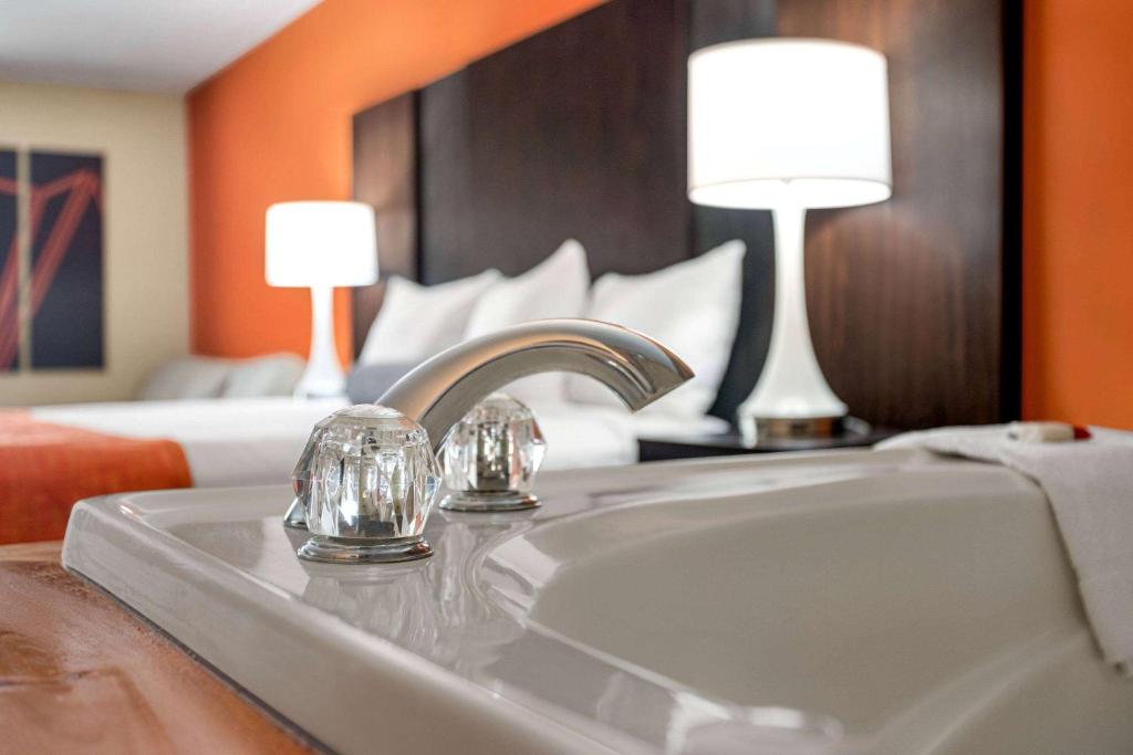 a bathroom with a sink and a bedroom with a bed at Howard Johnson by Wyndham Pigeon Forge in Pigeon Forge