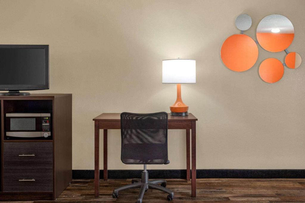 a desk with a chair and a lamp and a tv at Howard Johnson by Wyndham Pigeon Forge in Pigeon Forge