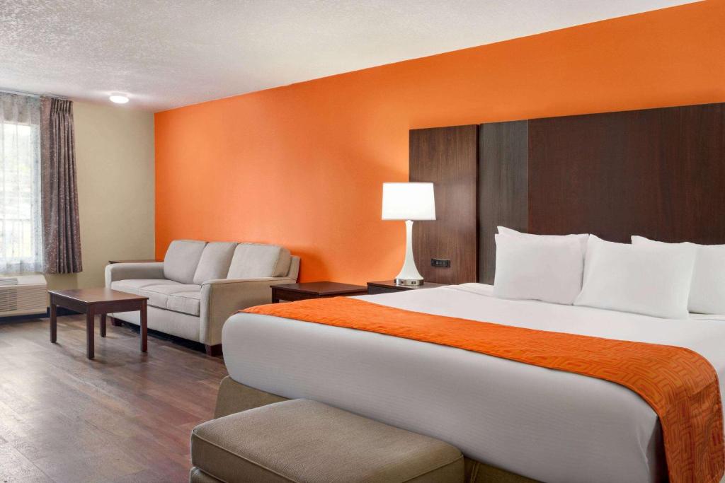 a hotel room with a large bed and a chair at Howard Johnson by Wyndham Pigeon Forge in Pigeon Forge