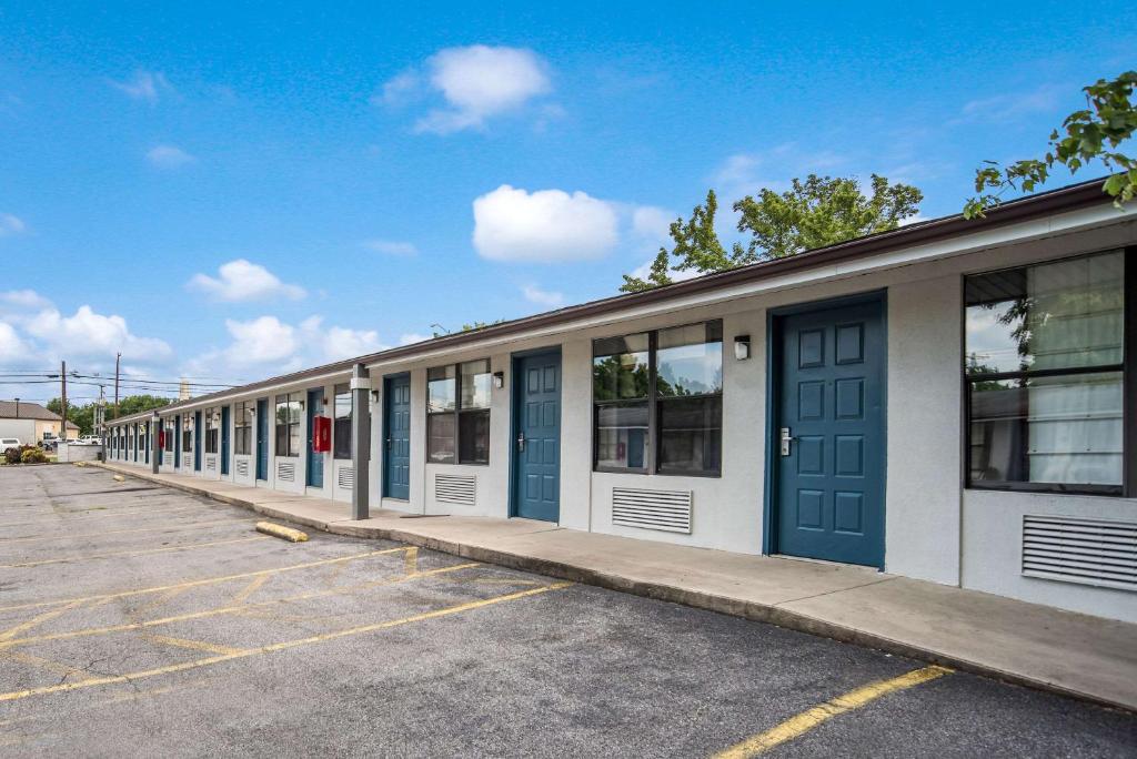 una fila de edificios con puertas azules en un estacionamiento en Rodeway Inn, en Carlisle