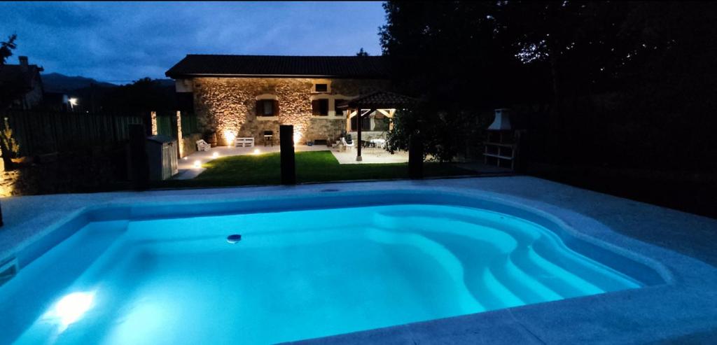 a swimming pool in a backyard at night at VillaMerceditas in Rasines