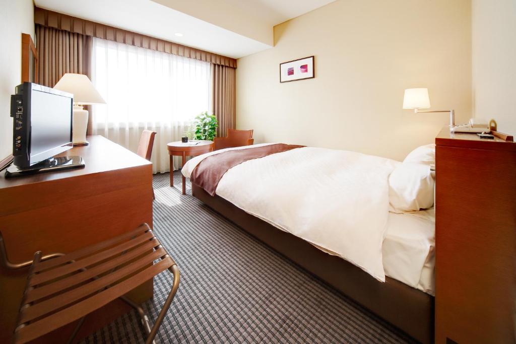 Postel nebo postele na pokoji v ubytování Meitetsu Grand Hotel
