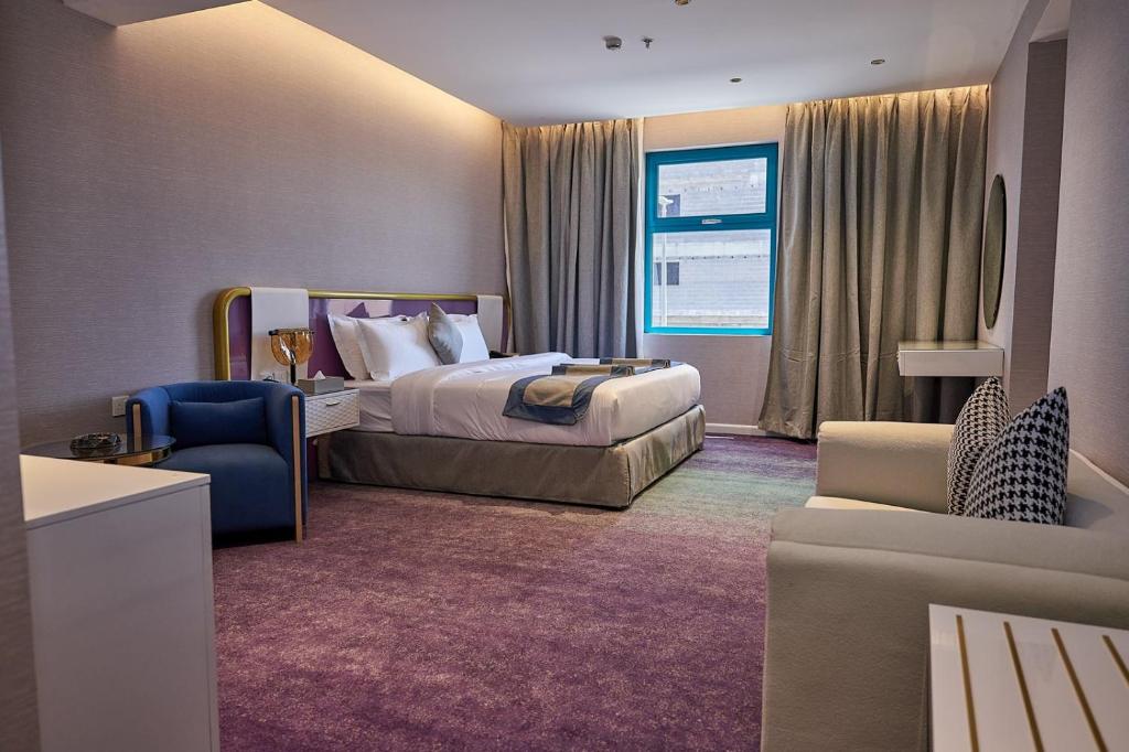 une chambre d'hôtel avec un lit et une chaise dans l'établissement Marvelous Hotel, à Tabuk