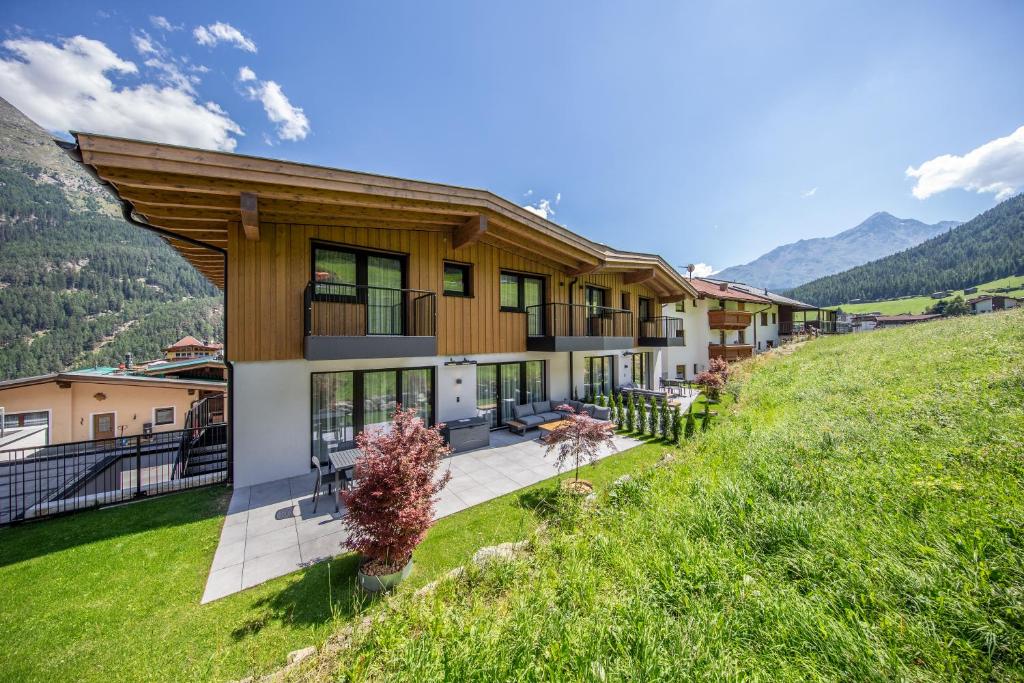 a house on a hill with mountains in the background at A CASA Brilliant in Sölden