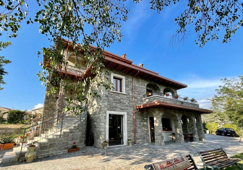 a stone house with a balcony on the side of it at Agriturismo Cupello in Cagnano Amiterno