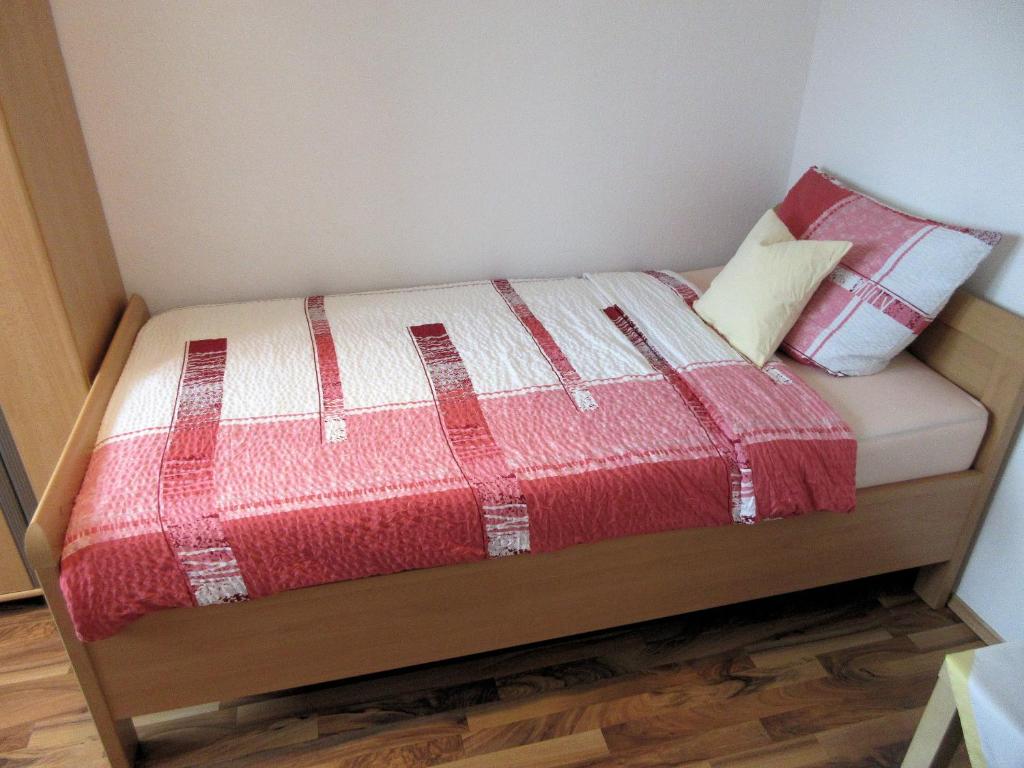 ハノーファーにあるPrivate Apartment near fair groundの小さなベッド(赤と白の毛布、枕付)