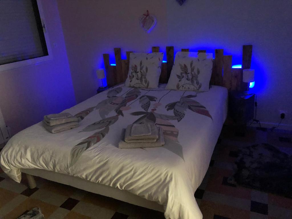 a bedroom with a large white bed with blue lights at Les gîtes de criquetot in Criquetot-le-Mauconduit
