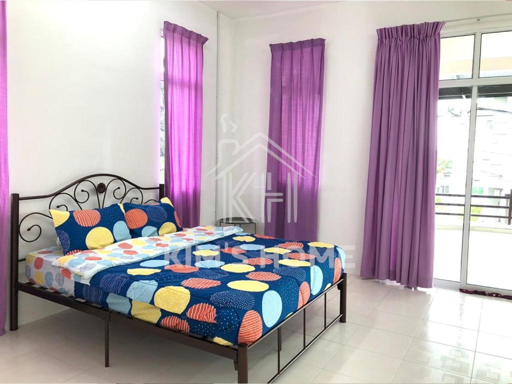 Dormitorio con cama con edredón colorido y cortinas moradas en Kim’s Home - Homey At Your Stay, en Nibung Tebal