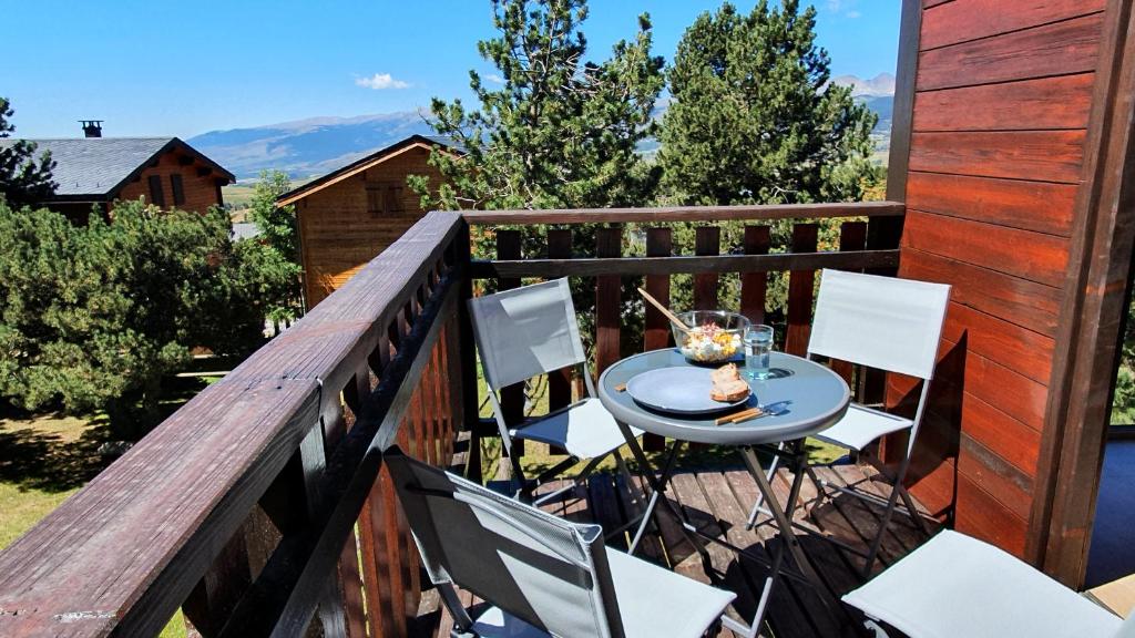 a balcony with a table and chairs on a deck at Chalet Individuel Les Sorbiers - 80m2 - Jardin - Barbecue - Wifi - Netflix - Ski & Randonnée - Pyrénées Catalanes Françaises - in Eyne