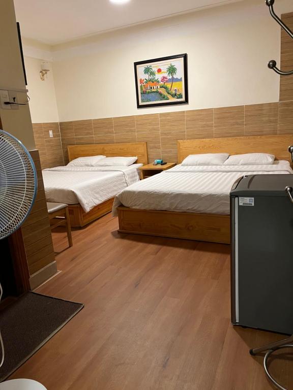 een slaapkamer met 2 bedden en een ventilator. bij Hostel Phuong Nga in Da Lat