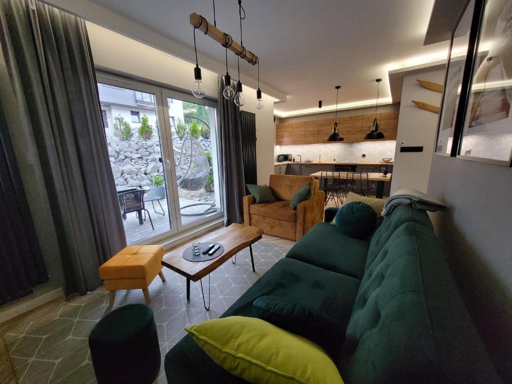 - un salon avec un canapé vert et une table dans l'établissement Apartament Wiślańskie Skije, à Wisła