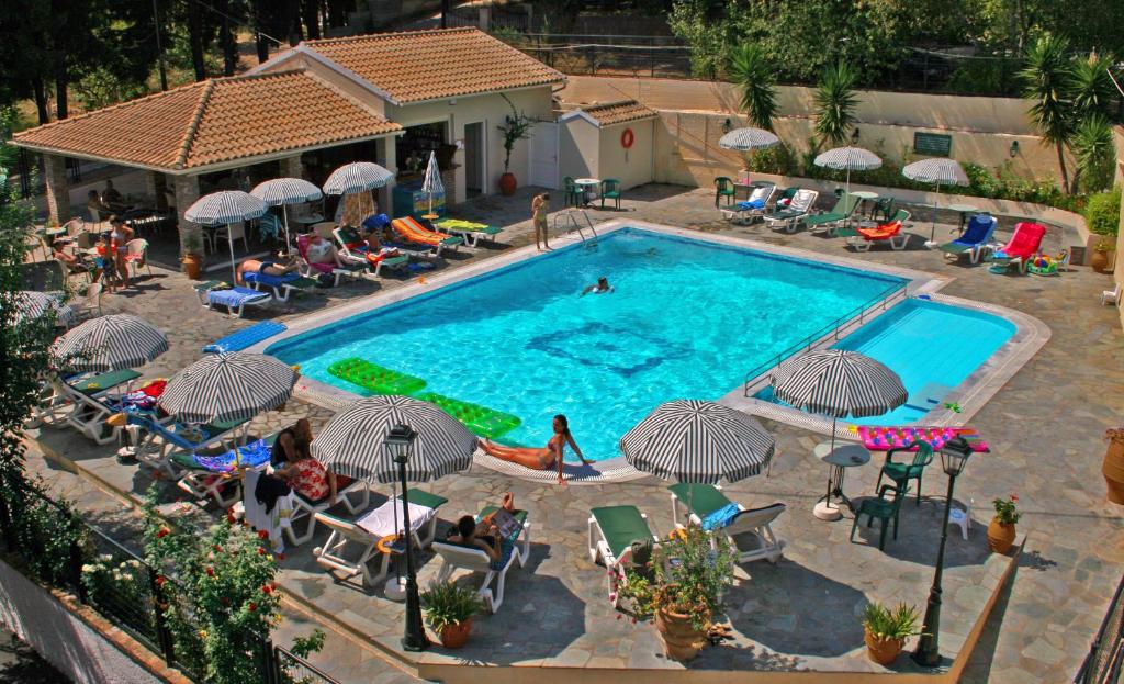 an overhead view of a swimming pool with people sitting around it at Elli Marina Studios and Apartments in Benitses