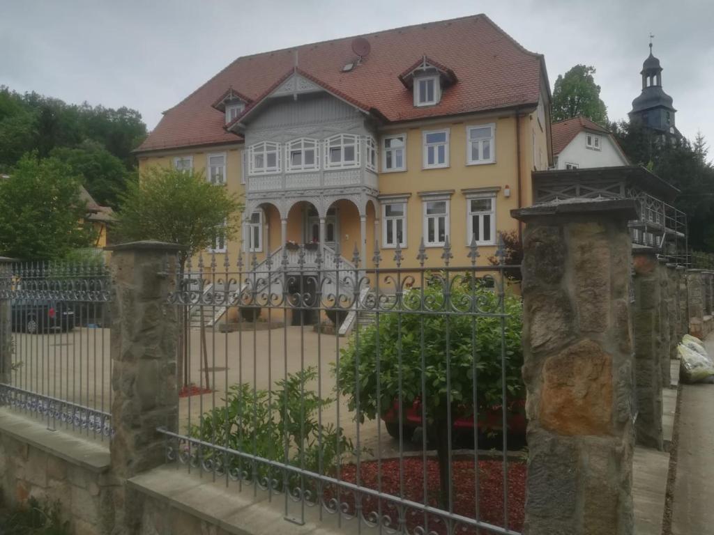 uma casa amarela com uma cerca em frente em FewoQuido 2 em Königsee