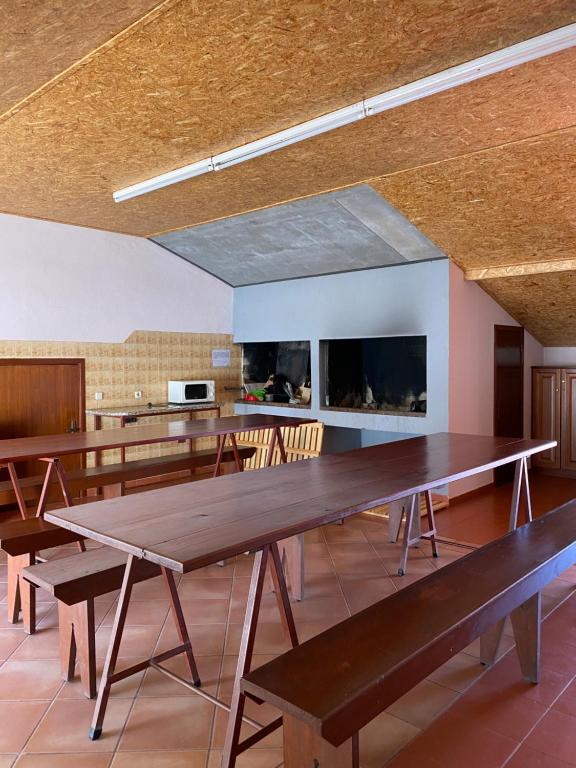 uma grande sala com mesas e cadeiras e uma lareira em The Palms Apartment em Madalena do Mar