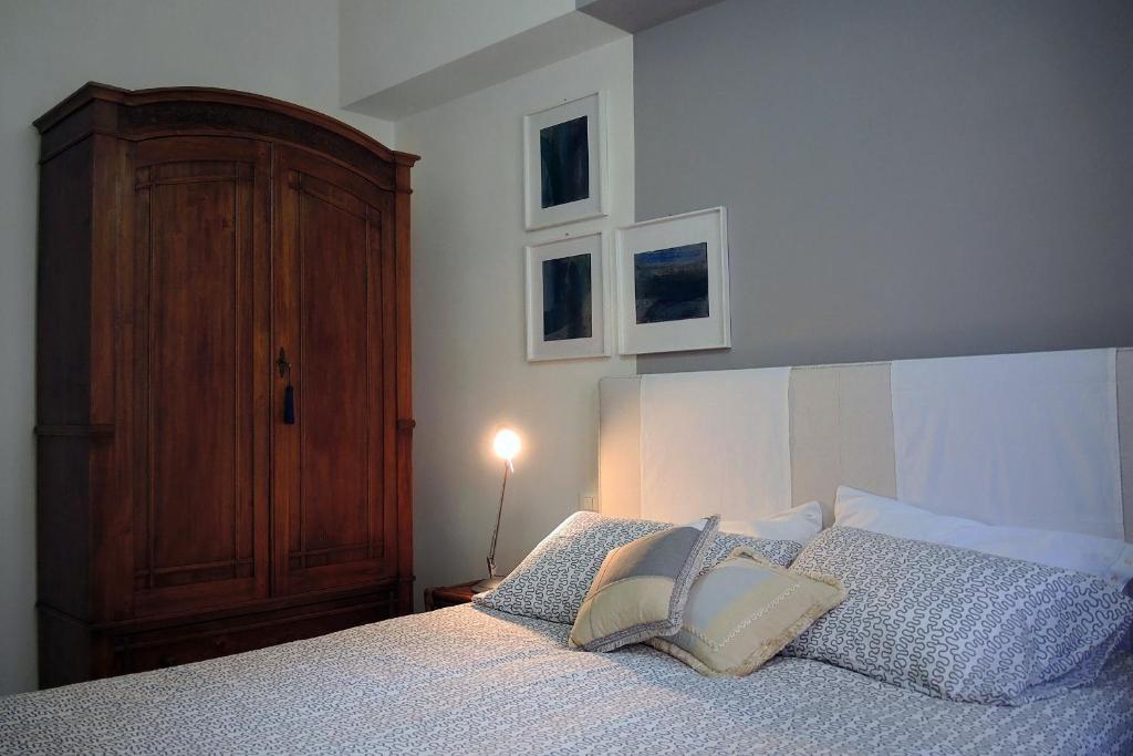 a bedroom with a bed with a wooden headboard and pillows at Dante 12 in Vigevano