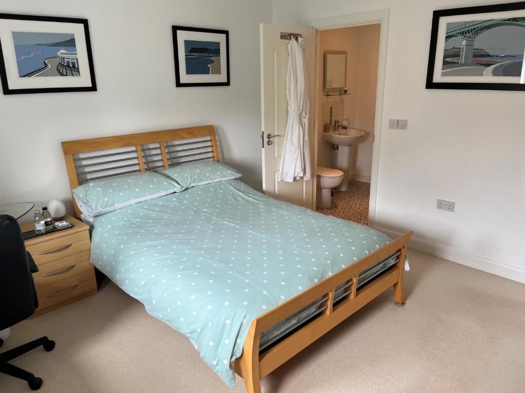 a bedroom with a bed and a dresser and a bathroom at Peterborough, Hampton Vale Lakeside En-Suite Large Double bedroom with great modern facilities in Peterborough