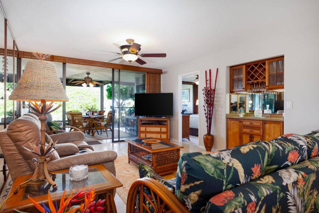 a living room with a couch and a tv at Country Club Villas 124 in Kailua-Kona
