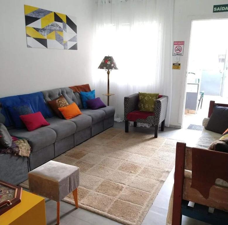 a living room with a gray couch with colorful pillows at Hospedaria da Mama in São Paulo