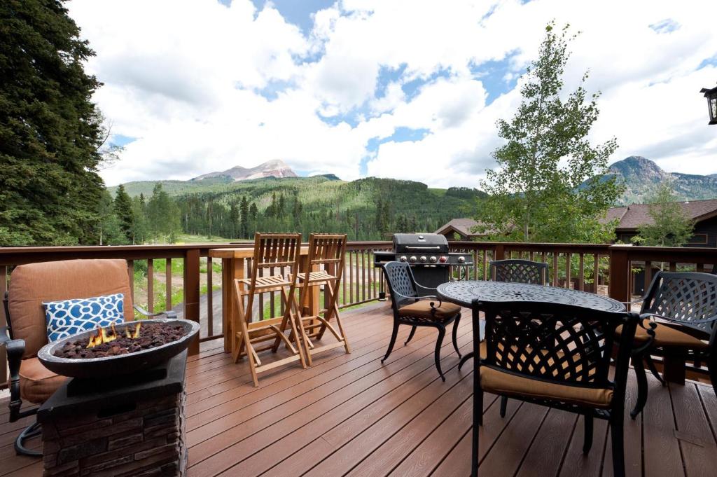 a deck with chairs and a table and a grill at Cascade Village 48 in Durango Mountain Resort