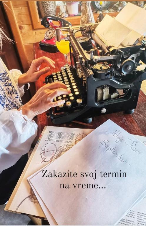 a person typing on an old typewriter on a desk at Brvnare Mrkic in Kremna