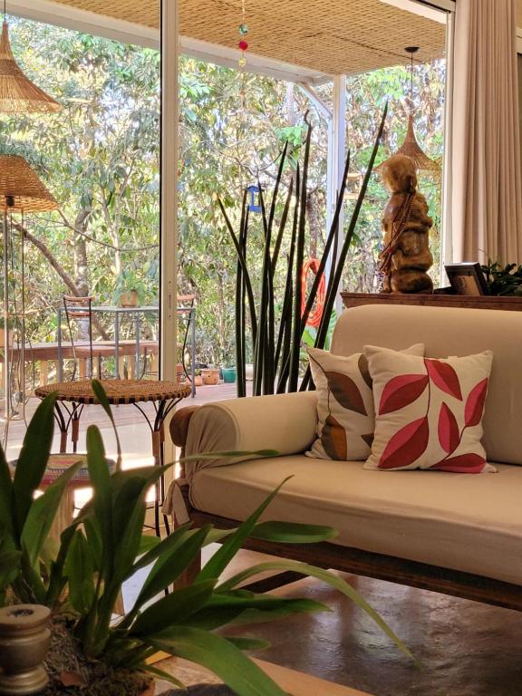 Casa Dharma - Conforto e Silêncio في ألتو بارايسو دي غوياس: غرفة معيشة مع أريكة ونافذة كبيرة