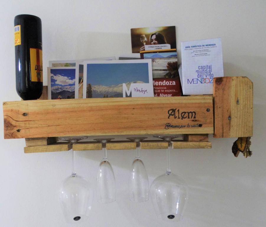 a wooden shelf with wine glasses and books on a wall at Alem Mendoza in Mendoza