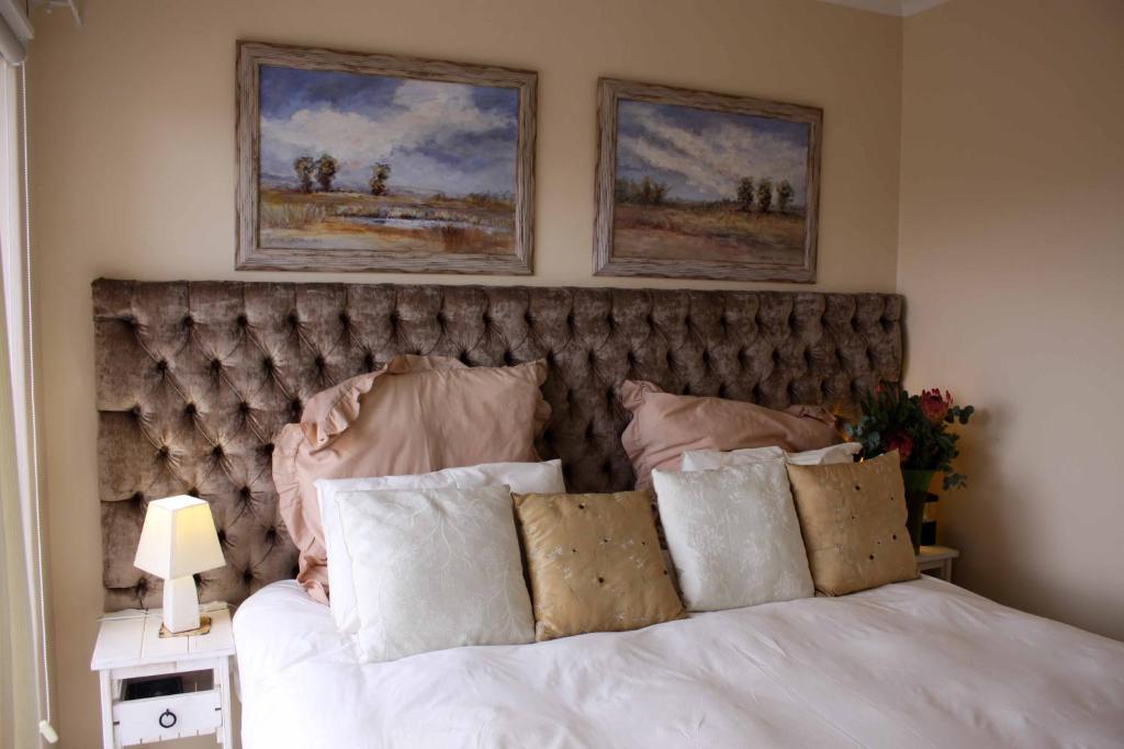 a bedroom with a bed with two pictures on the wall at Blougans B&B in Gansbaai