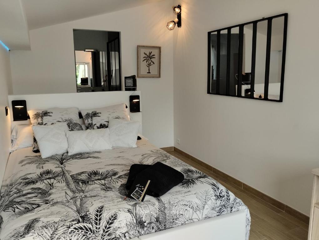 Un dormitorio con una cama con un libro. en L'Atelier Saint-Sulpice entre Bordeaux et St Emilion, en Saint-Sulpice-et-Cameyrac