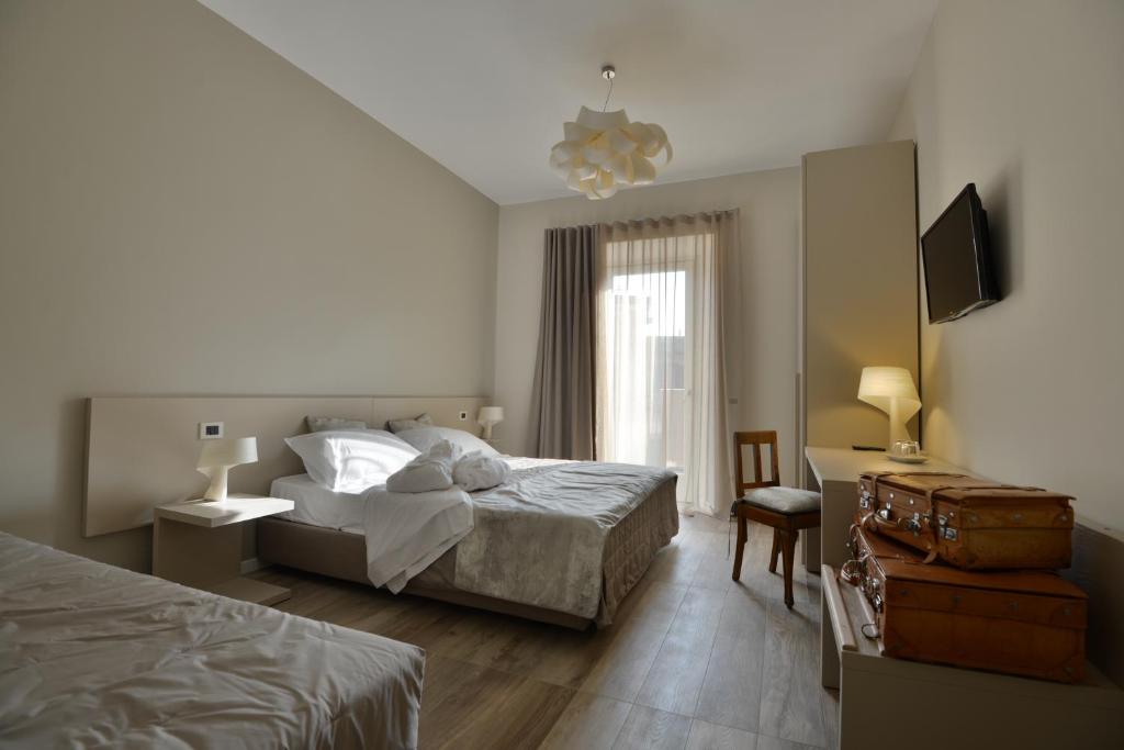1 dormitorio con 2 camas y TV. en Daman Rooms & Breakfast, en Barzago