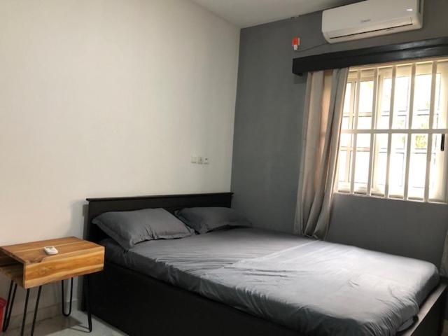 a bedroom with two beds and a table and a window at Villa Damas in Lomé