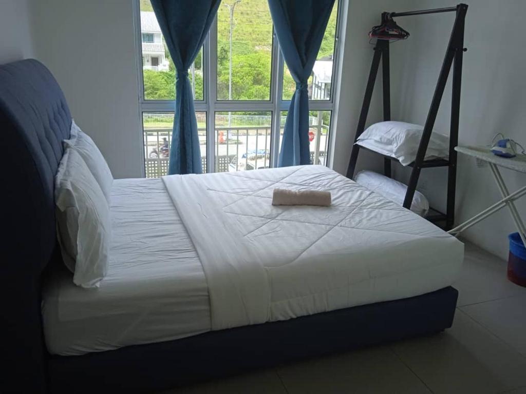 a bed with a towel on it in a room with a window at Cahaya Gardens 2 rooms at Golden Hills depan pasar malam in Brinchang