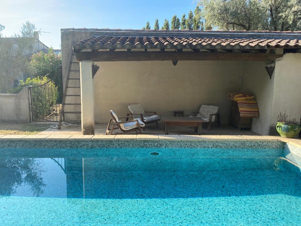 una piscina con pérgola, mesa y piscina en Eden, en Le Thor