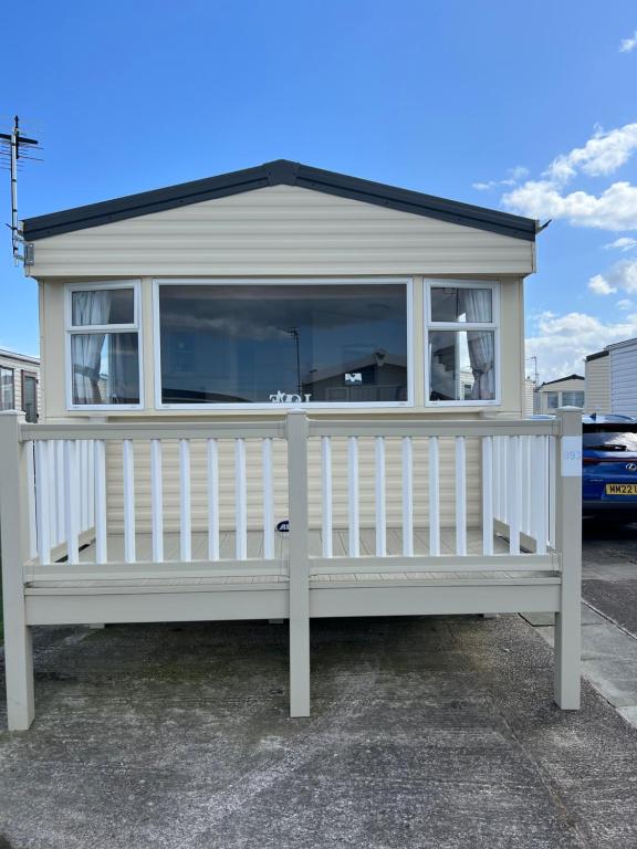 a small white house with a large window at Chris’s caravan in Abergele