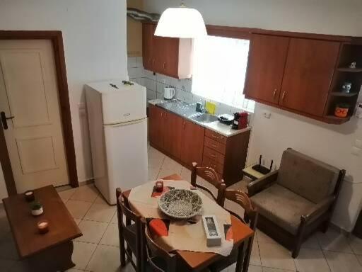 a kitchen with a table and chairs and a refrigerator at Samos House in Samos