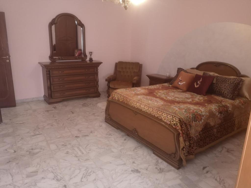 a bedroom with a bed and a dresser and a mirror at Casa vacanze Sofia in Irsina