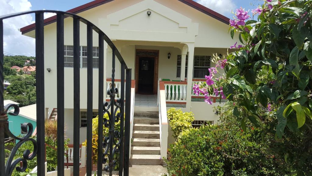 une maison avec un portail et des fleurs dans l'établissement Delightful 4bed modern villa with WiFI, à Gros Islet