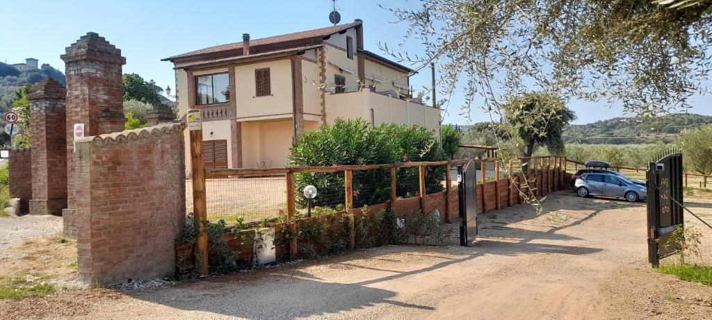 um portão para uma casa com um carro estacionado na frente em Agriturismo IL VECCHIO OLIVO em Castagneto Carducci