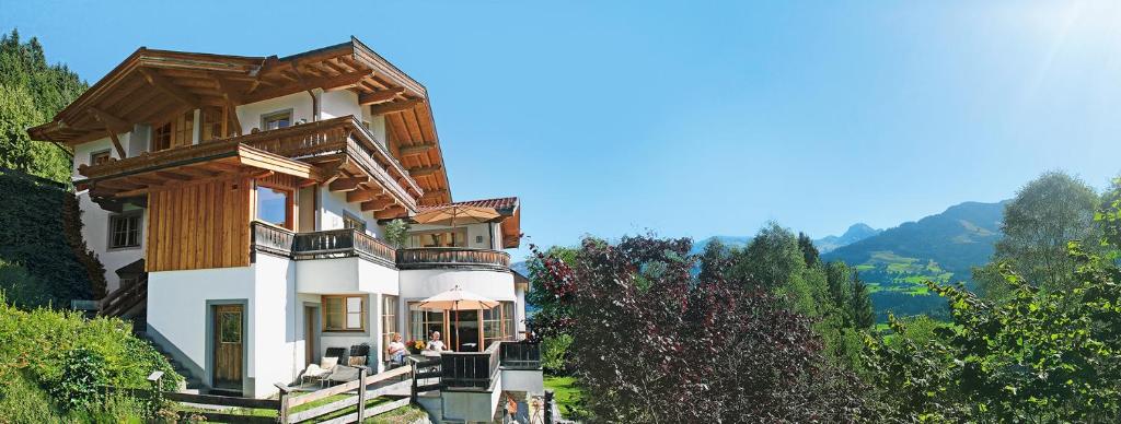 een huis op een heuvel met bergen op de achtergrond bij Residenz am Berg in Jochberg