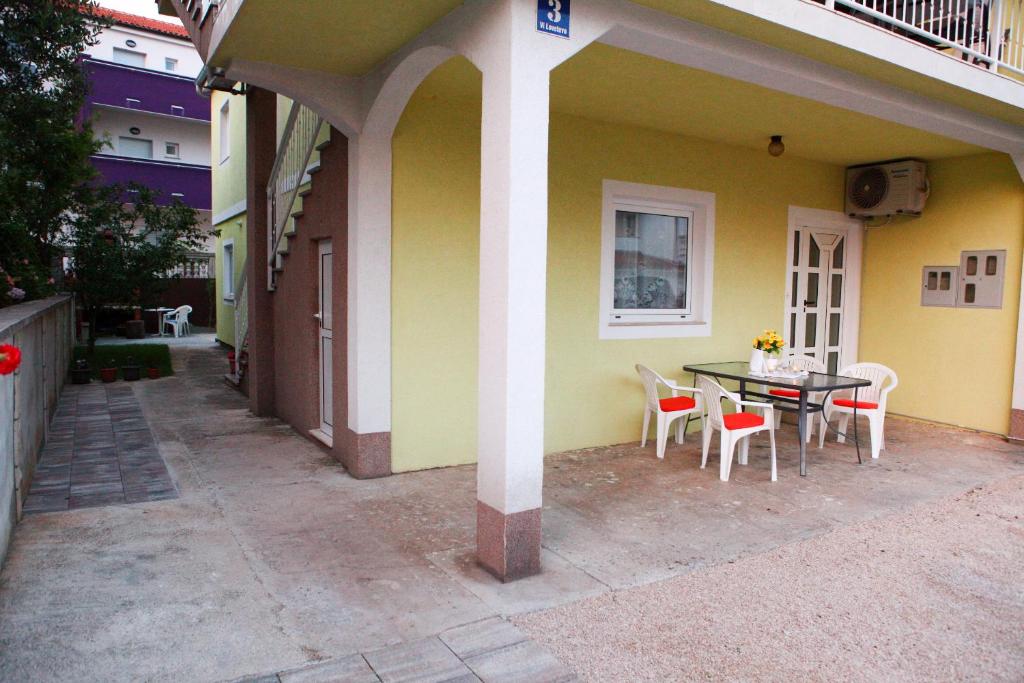 a table and chairs sitting outside of a house at Apartmani Andrej Vodice in Vodice