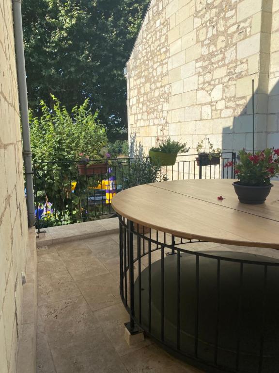 une terrasse avec une table en bois et quelques plantes dans l&#39;établissement Le Charles VII CHINON, à Chinon