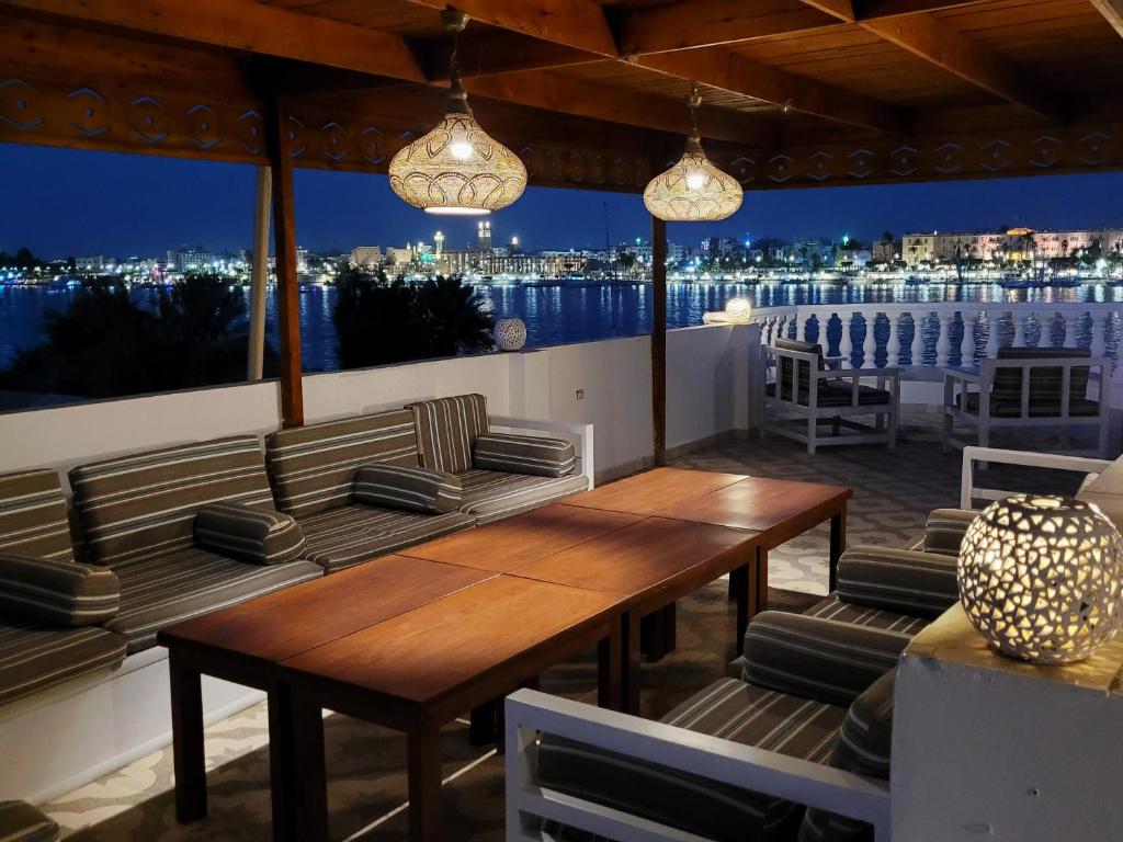 a patio with a table and chairs and a view of the city at IN LUXOR Nile Apartments in Luxor