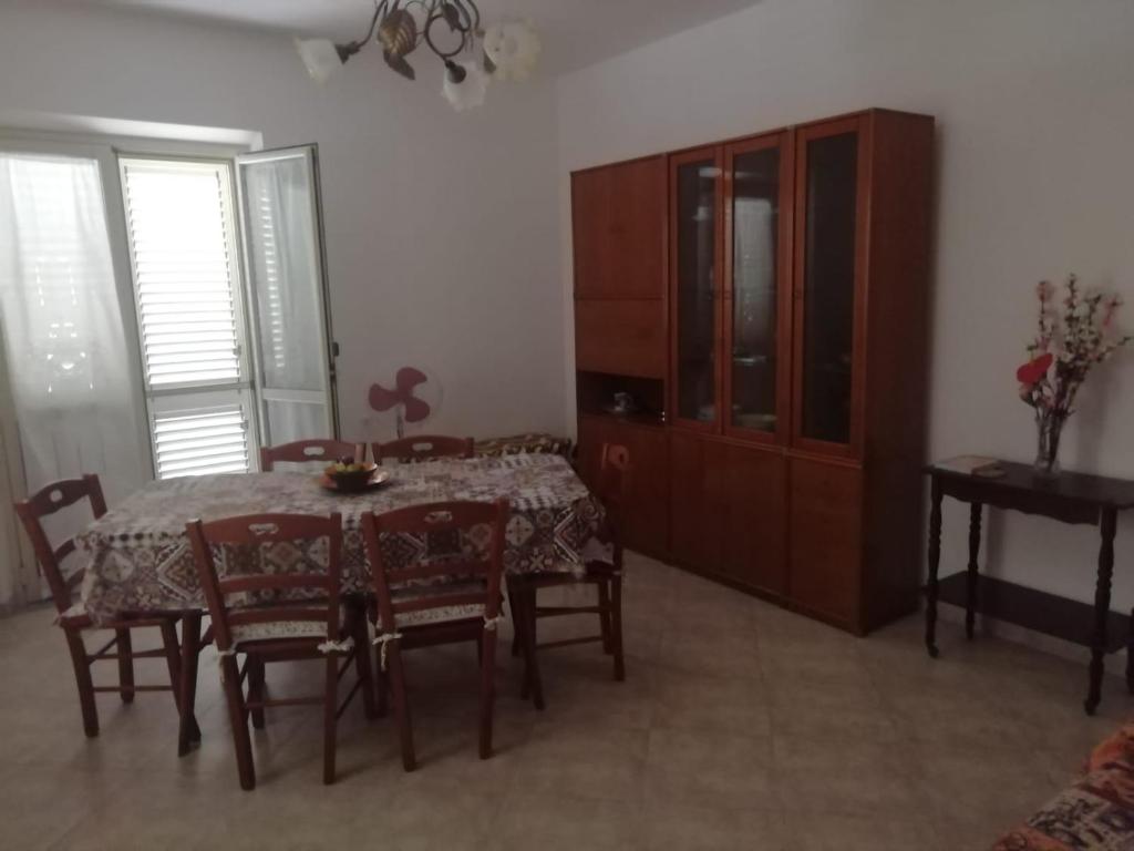 a dining room with a table and chairs and a cabinet at La Rosa dei Venti in Reggio di Calabria
