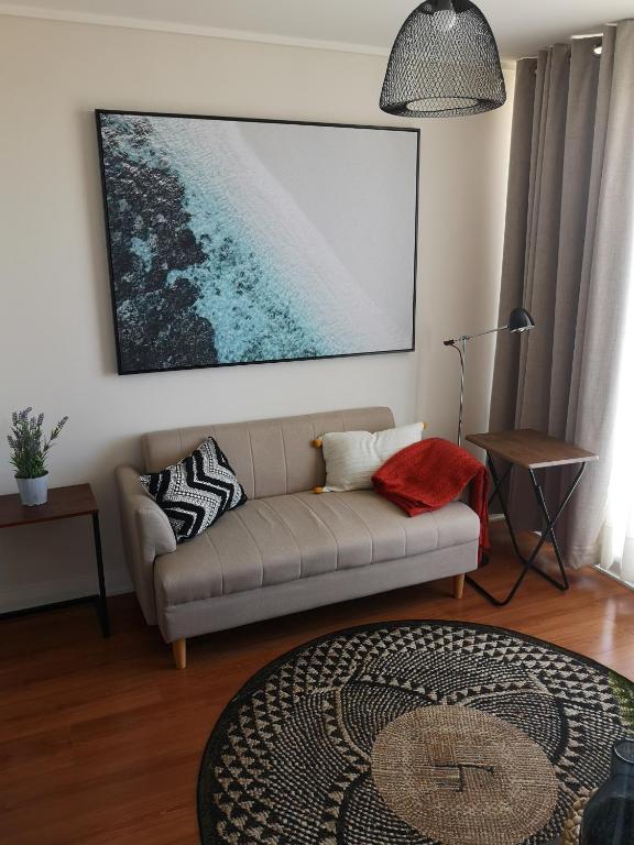 un soggiorno con divano e una foto appesa al muro di Tranquilo y Acogedor departamento en Con Con a Concón