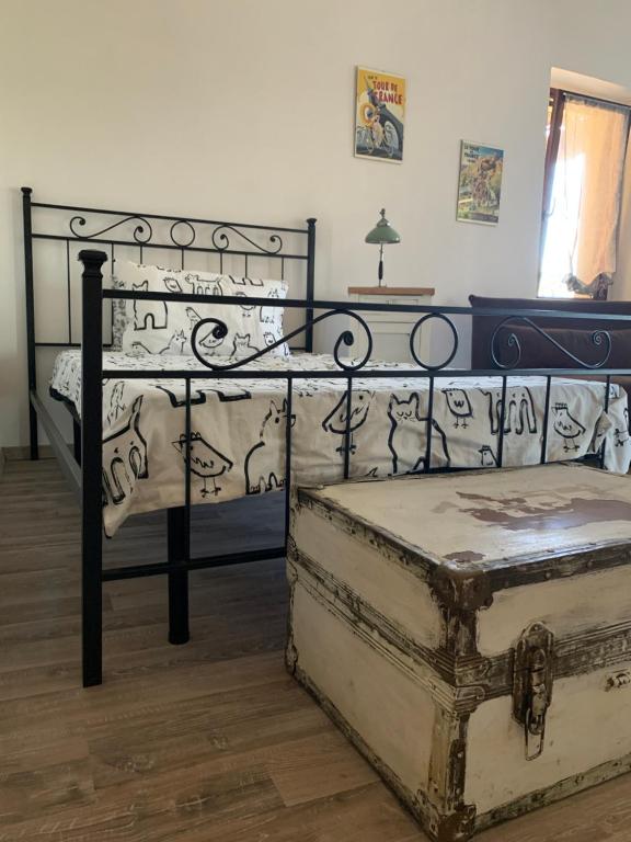 1 dormitorio con cama de metal y baúl en Cà del Prete country room, en Valenza