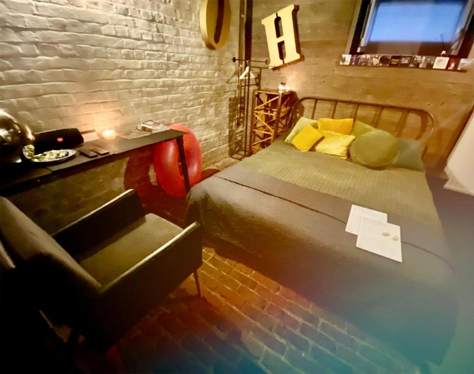 - une chambre avec un lit, une table et une chaise dans l'établissement Les chambres atypiques de Nico Bush - Parking sécurisé vélos, à Tournai