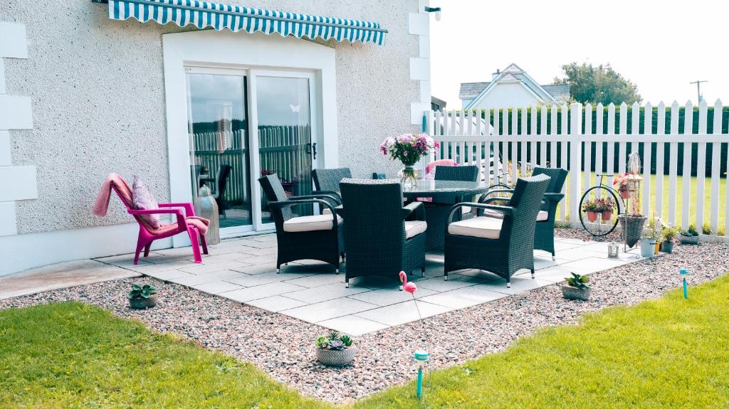 a patio with chairs and a table in a yard at Doonan Breeze in Donegal